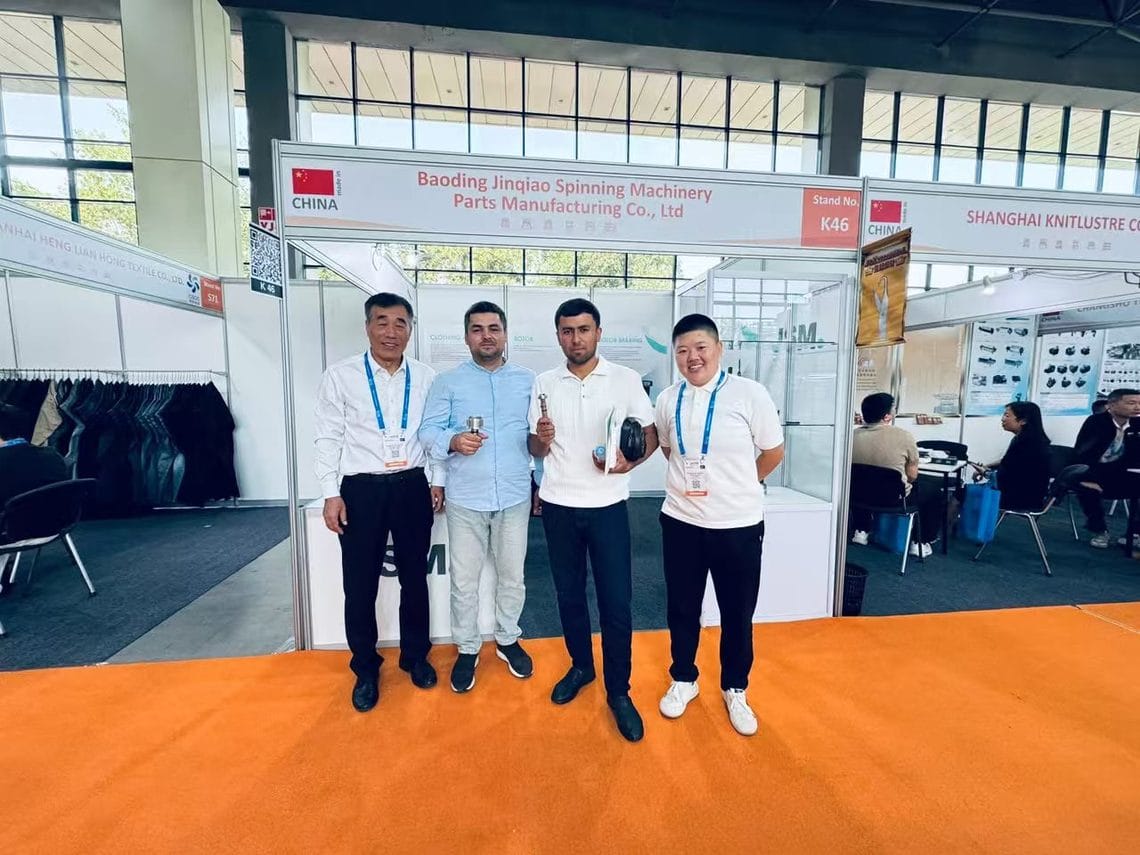 Two visitors holding JSM rotor cup and component samples with the JSM team in front of Stand K46 at CAITME 2026